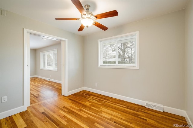 empty room with light wood-type flooring, a wealth of natural light, and ceiling fan