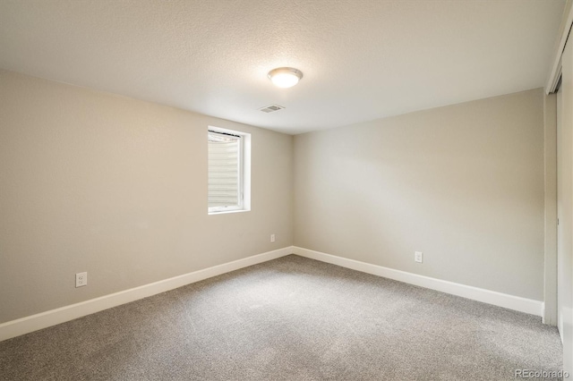 empty room featuring carpet and a textured ceiling