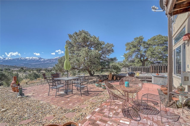 view of patio / terrace with a mountain view, fence, and outdoor dining space
