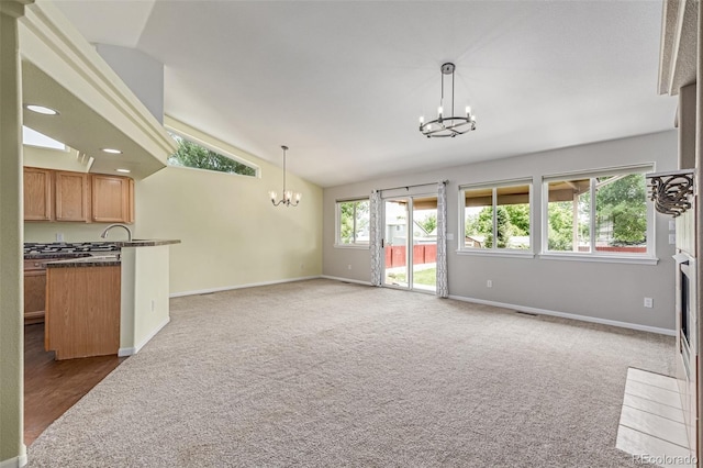 903 Cameron Dr, Severance, CO 80550 - unfurnished living room with a chandelier, lofted ceiling, carpet floors, a fireplace with flush hearth, and recessed lighting
