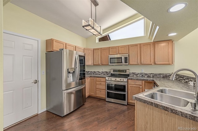 903 Cameron Dr, Severance, CO 80550 - kitchen featuring appliances with stainless steel finishes, vaulted ceiling, dark countertops, dark wood-type flooring, and recessed lighting