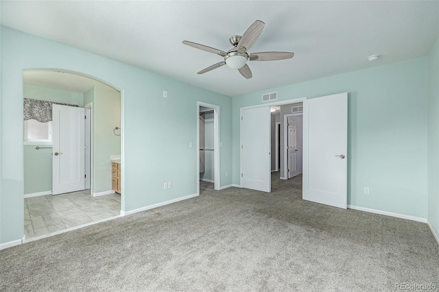 903 Cameron Dr, Severance, CO 80550 - unfurnished bedroom with a walk in closet, carpet floors, ensuite bathroom, and a ceiling fan