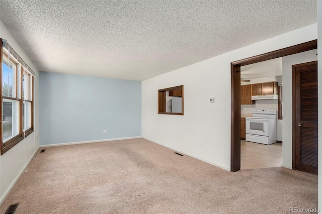 carpeted empty room with a textured ceiling