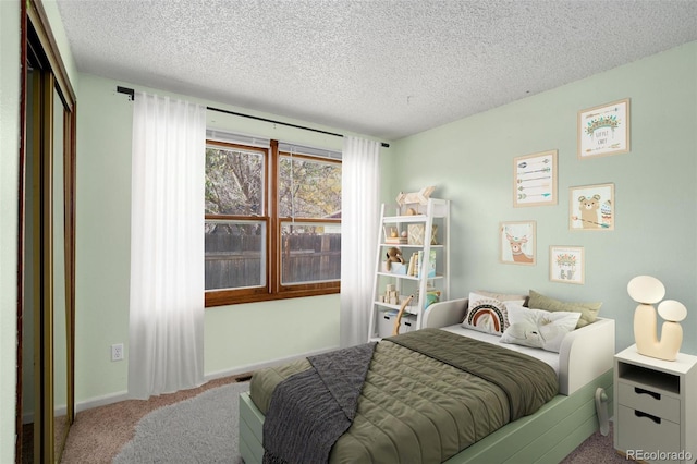 carpeted bedroom with a closet and a textured ceiling