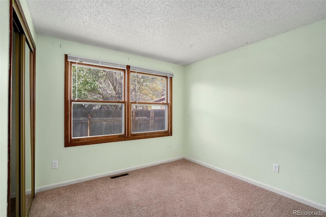 spare room with carpet floors and a textured ceiling