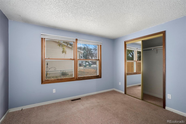 unfurnished bedroom with a closet, a textured ceiling, and carpet flooring