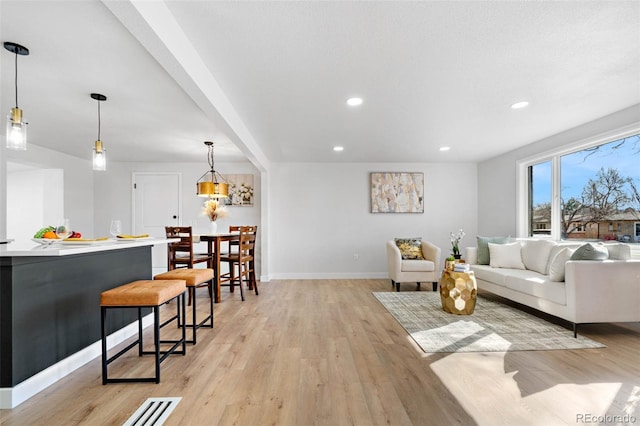 living area featuring recessed lighting, light wood-type flooring, and baseboards