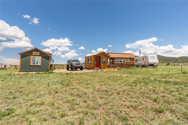 view of yard with a rural view and an outdoor structure