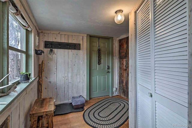 interior space with wood walls and light hardwood / wood-style flooring