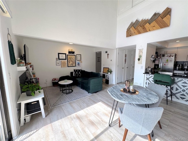 living area featuring a high ceiling and light wood-style floors