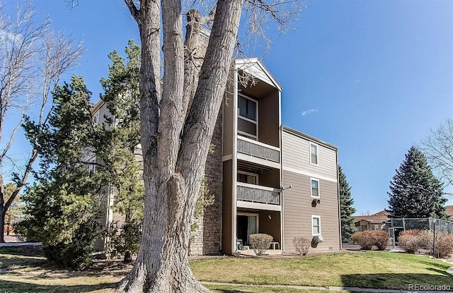 back of property featuring a lawn and a balcony