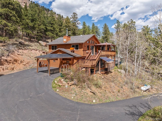 29 Cedar Ln, Bailey, CO 80421 - rustic home with driveway, a wooden deck, stairway, and a chimney