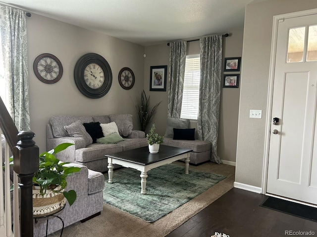 living room with dark wood-type flooring and baseboards