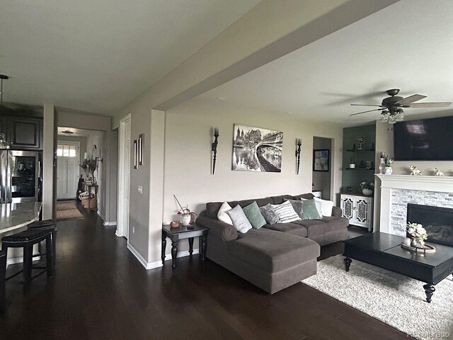 living room featuring a fireplace, dark hardwood / wood-style floors, and ceiling fan