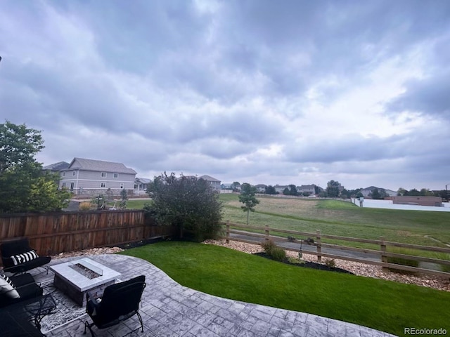 view of yard featuring a patio area, fence, and a fire pit