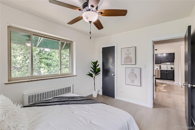 2100 N Franklin St Unit 20, Denver, CO 80205 - bedroom with radiator, light wood finished floors, and ceiling fan