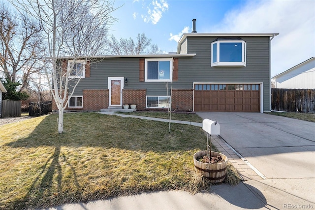 bi-level home featuring entry steps, driveway, fence, a front lawn, and brick siding