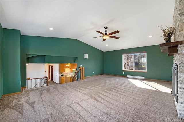 unfurnished living room featuring carpet floors, a fireplace, a baseboard heating unit, vaulted ceiling, and baseboards