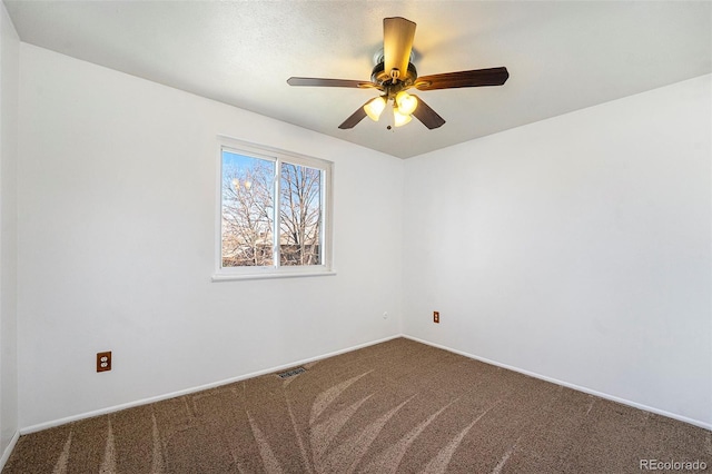 carpeted empty room with visible vents, ceiling fan, and baseboards