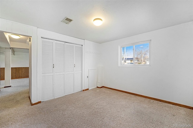 unfurnished bedroom with carpet floors, a closet, visible vents, and baseboards