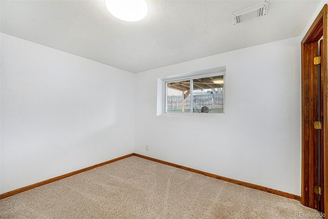 unfurnished room with baseboards, visible vents, a textured ceiling, and carpet flooring