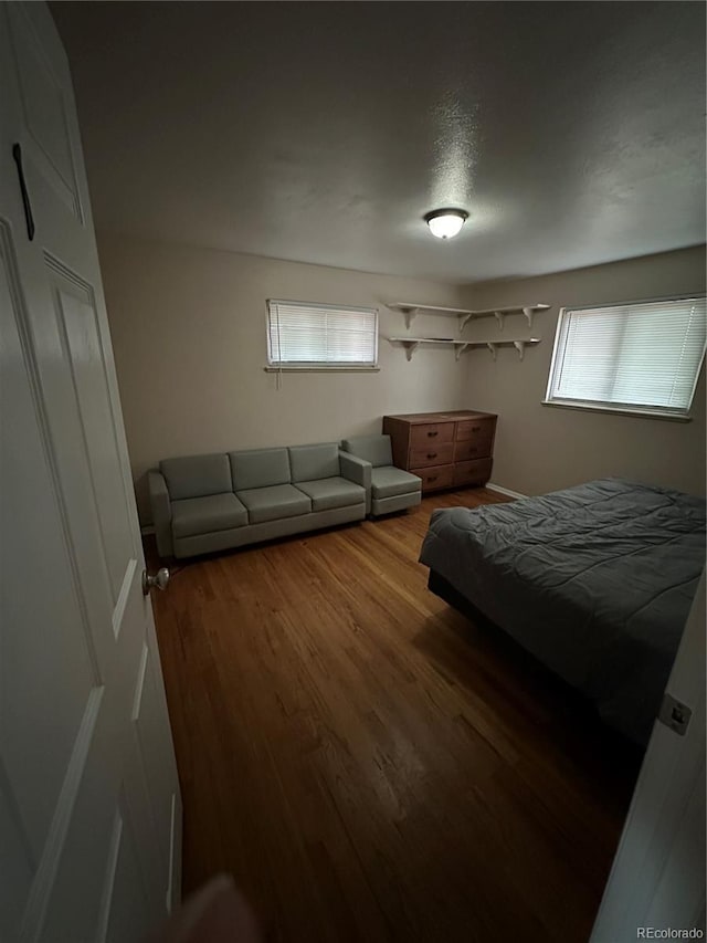 bedroom with hardwood / wood-style floors and multiple windows