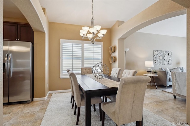dining area with arched walkways, baseboards, and an inviting chandelier