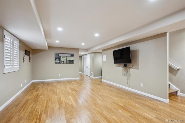basement featuring recessed lighting, baseboards, stairway, and light wood-style flooring