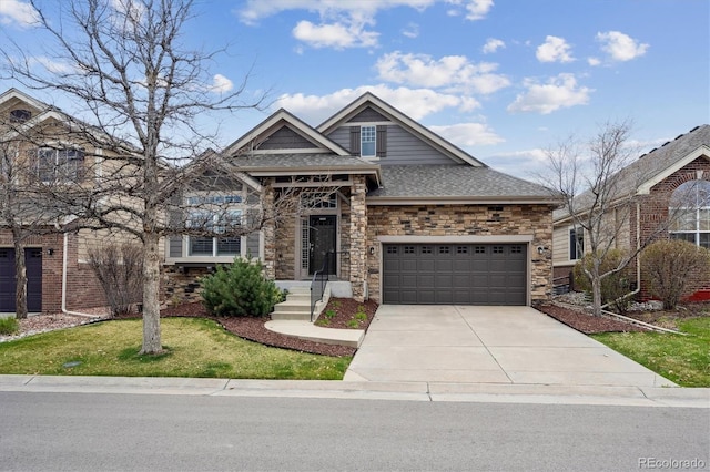 view of front of home with driveway, stone siding, a shingled roof, an attached garage, and a front yard