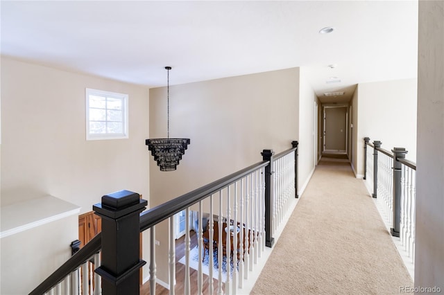 corridor featuring light colored carpet and a chandelier