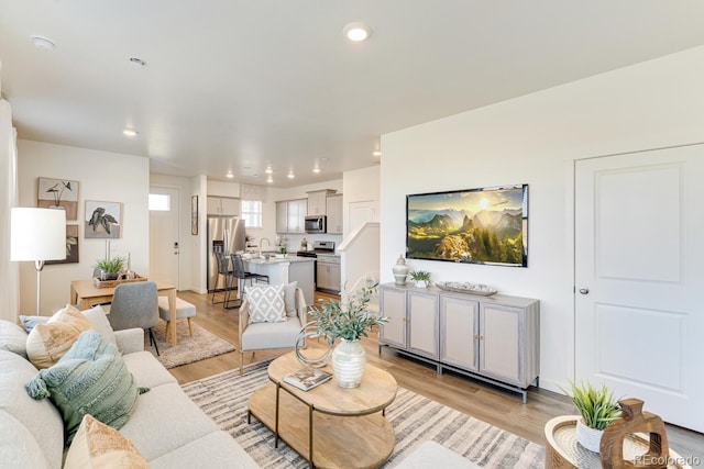 living area with light wood finished floors and recessed lighting