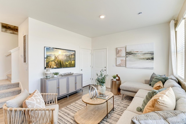 living room featuring stairway, recessed lighting, light wood-style flooring, and a healthy amount of sunlight