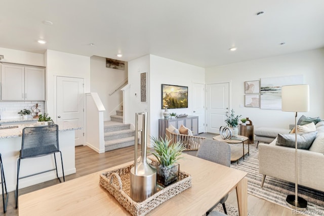 living area featuring light wood-type flooring, stairway, and recessed lighting