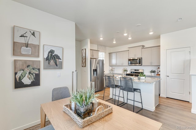 dining area featuring light wood-style floors, baseboards, and recessed lighting