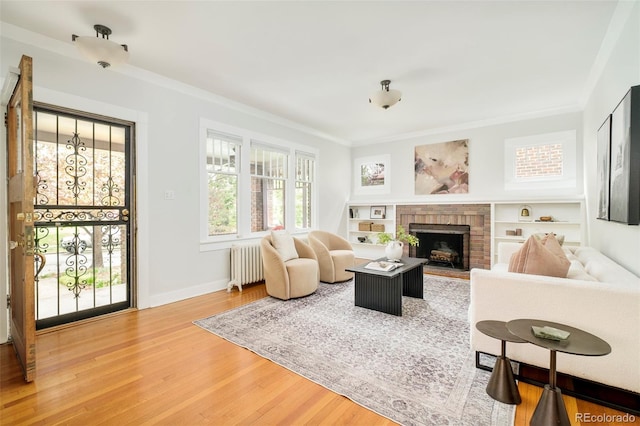 730 Cook St, Denver, CO 80206 - living room with radiator, wood finished floors, ornamental molding, a brick fireplace, and baseboards