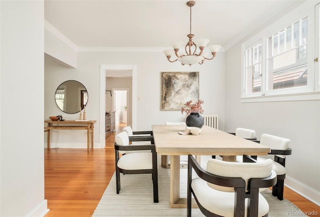 730 Cook St, Denver, CO 80206 - dining space featuring a chandelier, ornamental molding, light wood finished floors, and baseboards