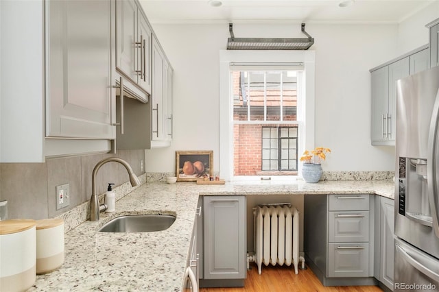 730 Cook St, Denver, CO 80206 - kitchen featuring gray cabinetry, stainless steel fridge with ice dispenser, radiator, a sink, and ornamental molding