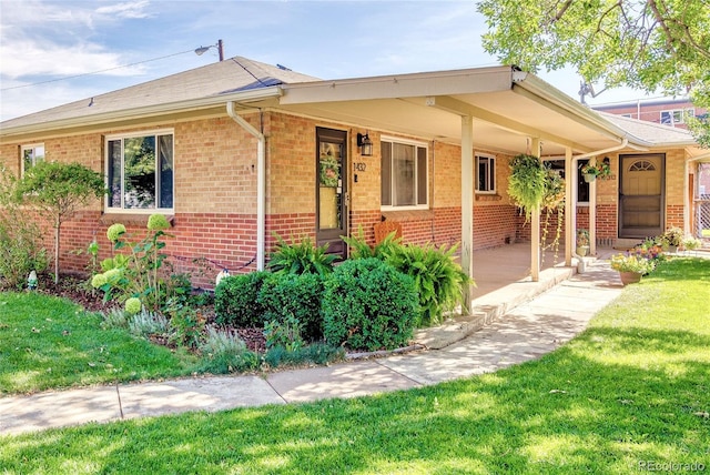 ranch-style house with covered porch and a front lawn