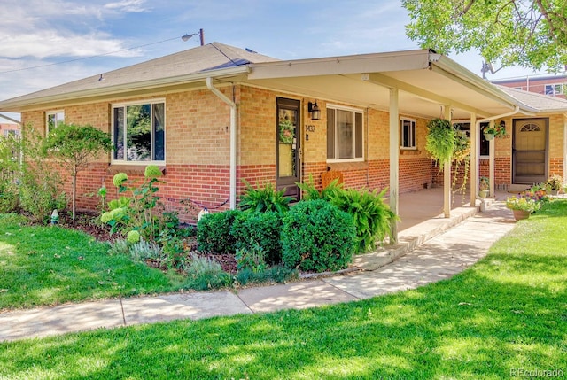 ranch-style home with covered porch and a front yard