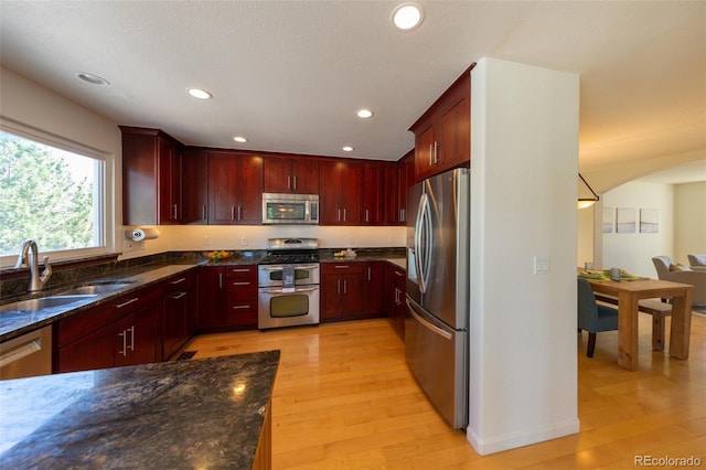 1881 Alma Ln, Superior, CO 80027 - kitchen with stainless steel appliances, reddish brown cabinets, light wood-type flooring, recessed lighting, and dark stone counters
