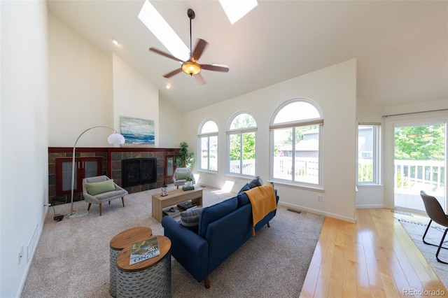 1881 Alma Ln, Superior, CO 80027 - living area with a skylight, a tile fireplace, high vaulted ceiling, light wood finished floors, and a ceiling fan