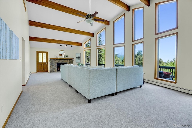 11333 Conifer Mountain Rd, Conifer, CO 80433 - living room with healthy amount of natural light, beamed ceiling, light colored carpet, ceiling fan, and a stone fireplace