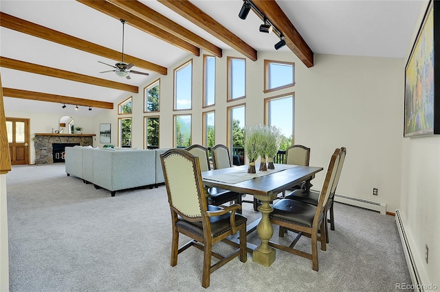 11333 Conifer Mountain Rd, Conifer, CO 80433 - dining room featuring a baseboard heating unit, light colored carpet, baseboard heating, ceiling fan, and a stone fireplace