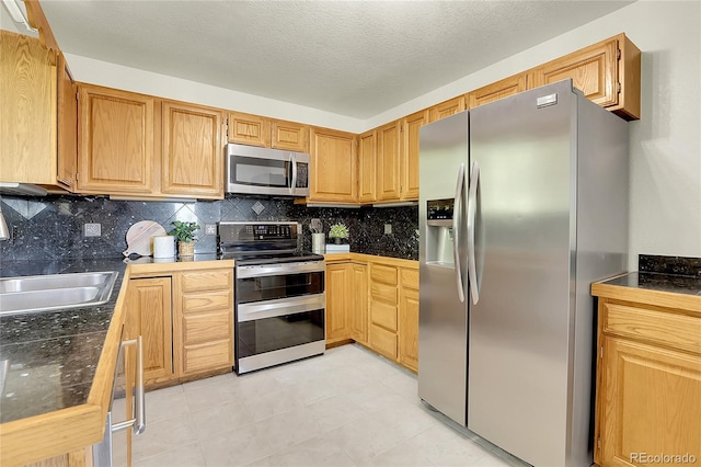 11333 Conifer Mountain Rd, Conifer, CO 80433 - kitchen featuring stainless steel appliances, tasteful backsplash, dark countertops, and light tile patterned flooring