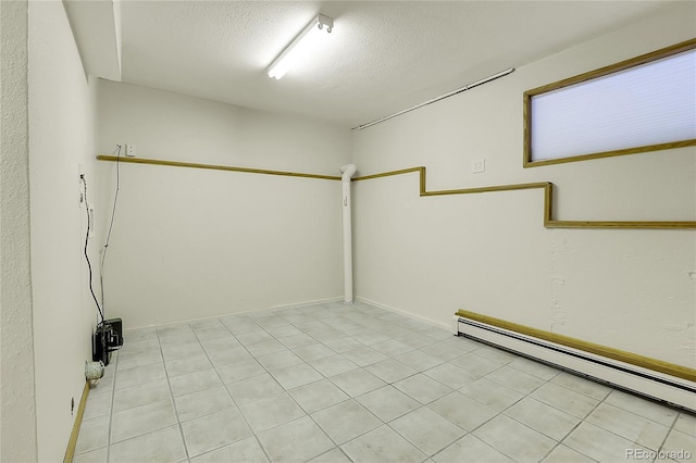 11333 Conifer Mountain Rd, Conifer, CO 80433 - unfurnished room featuring baseboard heating, a textured ceiling, and light tile patterned flooring