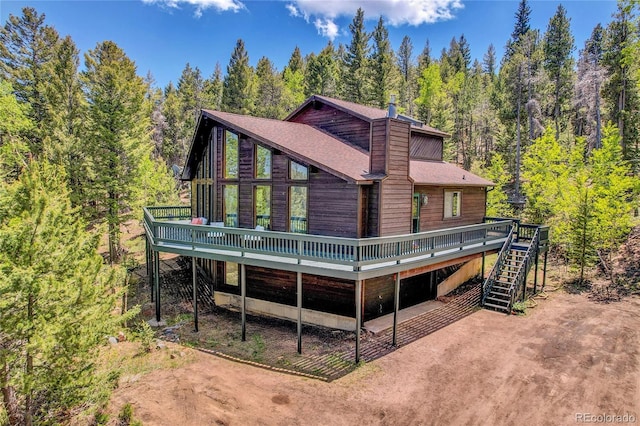 11333 Conifer Mountain Rd, Conifer, CO 80433 - rear view of property featuring a wooden deck, stairs, a wooded view, and a chimney
