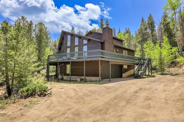 11333 Conifer Mountain Rd, Conifer, CO 80433 - rear view of property with dirt driveway, a wooden deck, stairway, and a chimney