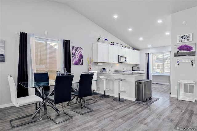 2742 Show Hunter Way, Colorado Springs, CO 80922 - dining area featuring light wood-type flooring, recessed lighting, baseboards, and high vaulted ceiling
