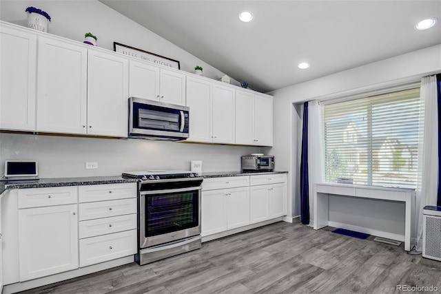 2742 Show Hunter Way, Colorado Springs, CO 80922 - kitchen featuring appliances with stainless steel finishes, vaulted ceiling, recessed lighting, white cabinetry, and light wood-style floors