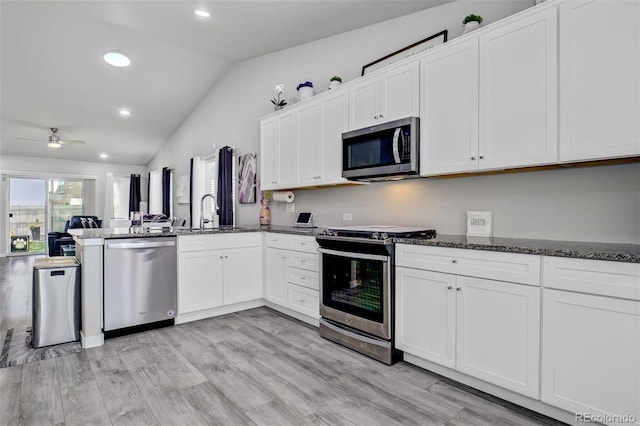 2742 Show Hunter Way, Colorado Springs, CO 80922 - kitchen with appliances with stainless steel finishes, a sink, lofted ceiling, a peninsula, and dark stone counters